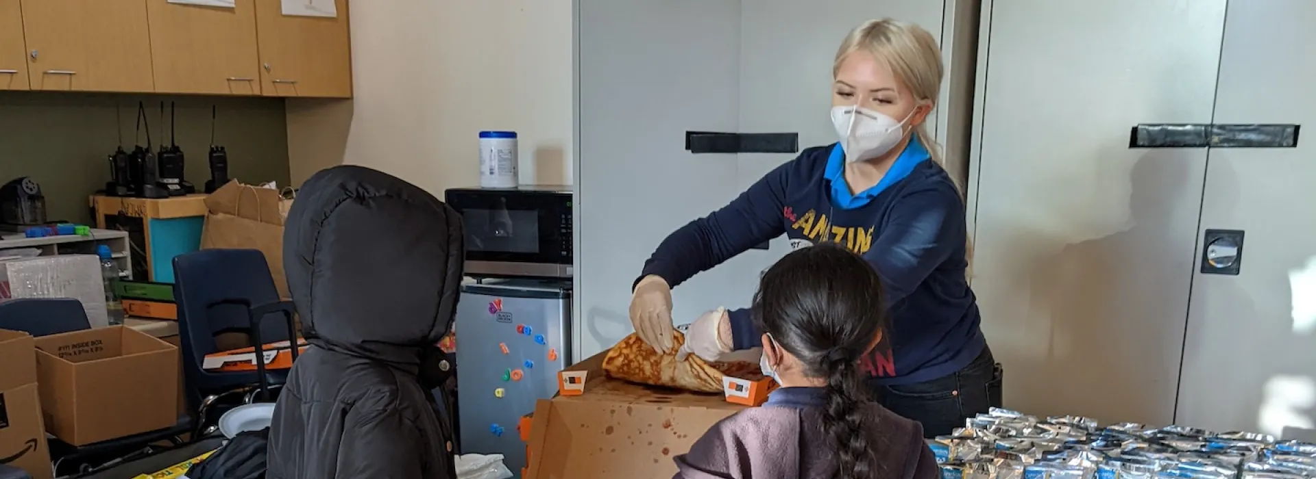 Staff serving pizza to Chavez students
