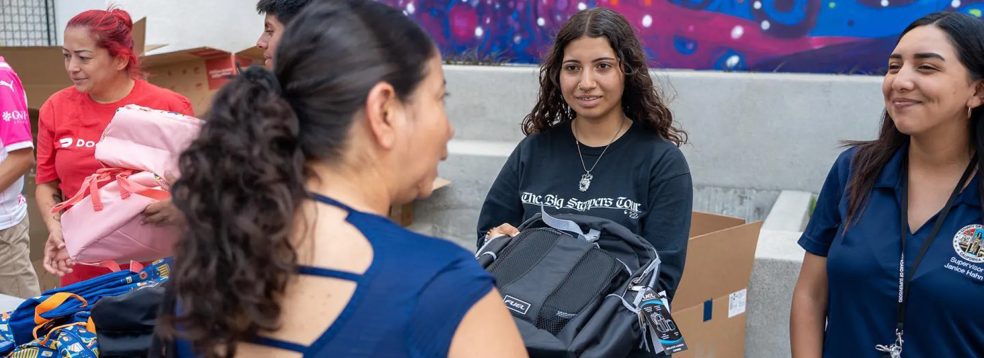 Communities leaders, teen volunteers and families smiling